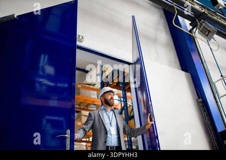 Senior industrial manager in modern factory. Senior industrial manager in modern factory, wearing suit. model released Stock Photo