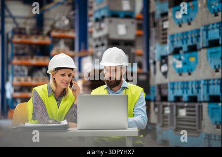 Industrial team analyzing data in high tech manufacturing plant. Industrial team analyzing data or managing operations in high tech manufacturing plan Stock Photo
