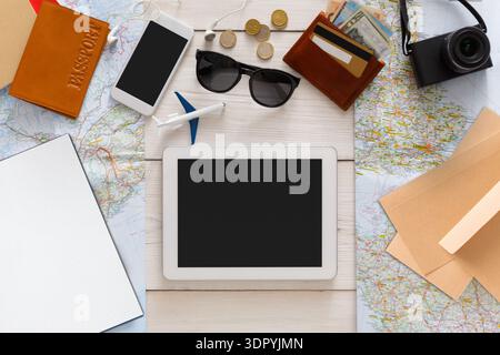 Travel Planning Setup With Maps, Digital Devices, and Travel Essentials on a Wooden Table Stock Photo