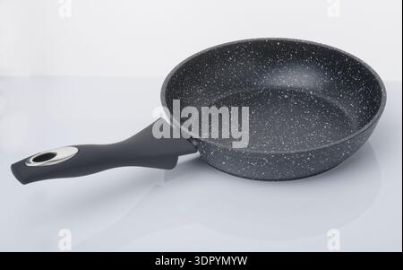 A modern multi stove frying pan. One which works on gas, electric, halogen & induction hobs. Cooking pan with granite coating. Stock Photo