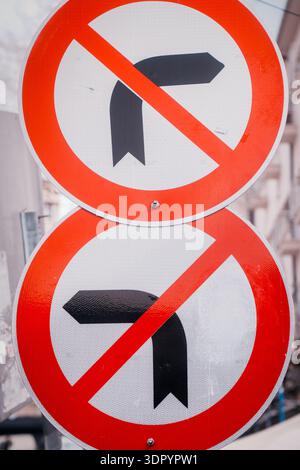 There are two red and white no turn signs on a pole. Traffic signs indicating no right or left turns. Stock Photo