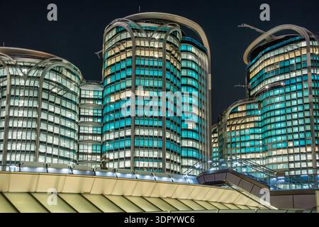 Modern office buildings with illuminated glass facade at night in Hong Kong city, China. Innovation and technology. Urban business infrastructure in Stock Photo