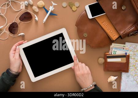 Preparing for Travel With a Tablet, Money, and Travel Items on a Table Stock Photo