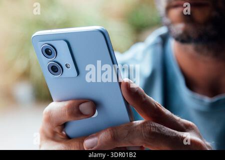 Closeup of adult unrecognizable man hand using mobile phone outdoors. Typing, browsing internet, checking social media, using an app. Modern communica Stock Photo