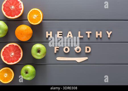 Fresh Fruits and Wooden Letters Forming a Message About Healthy Food on a Gray Table Stock Photo