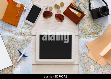 Travel Planning Tools Laid out on a Table With Maps, Devices, and Personal Items in a Bright Setting Stock Photo