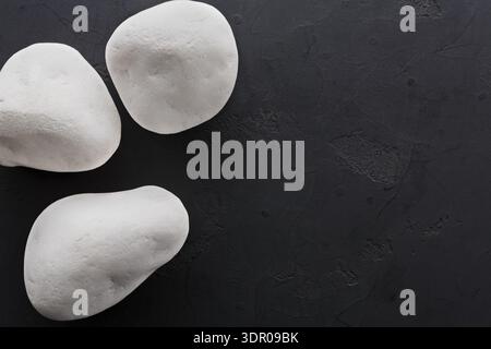 White Stones Arranged on a Dark Surface for a Simple Natural Display Stock Photo