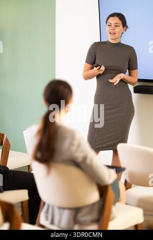 young woman giving a speech to a team of specialists Stock Photo