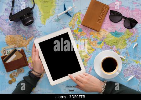 Travel Planning With a Tablet and Essentials on a World Map in a Cozy Workspace Stock Photo