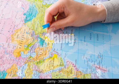 Pinning a Location on a Colorful Map in the Afternoon Light Stock Photo