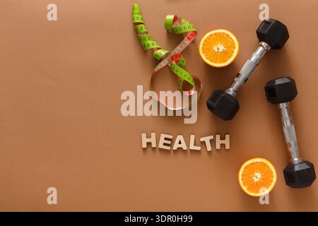 Health and Wellness Items With Dumbbells and Oranges on Brown Background Stock Photo