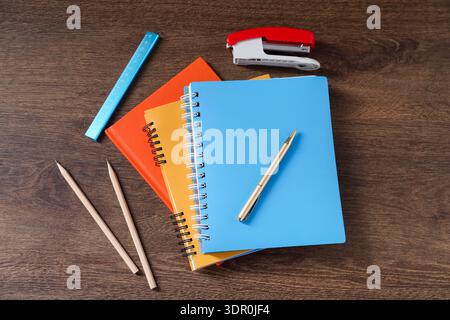 Homework. Notebooks and different stationery on wooden table Stock Photo