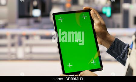Solar panels plant technician uses green screen tablet to oversee systems. Photovoltaics plant employee uses software on chroma key device to maintain operations, camera B close up Stock Photo
