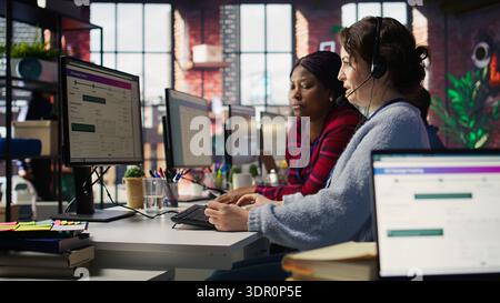 Account manager supervising work done by employee talking with customers to identify sales opportunities. Supervisor overseeing agent in office bonding with client to generate leads, camera B Stock Photo