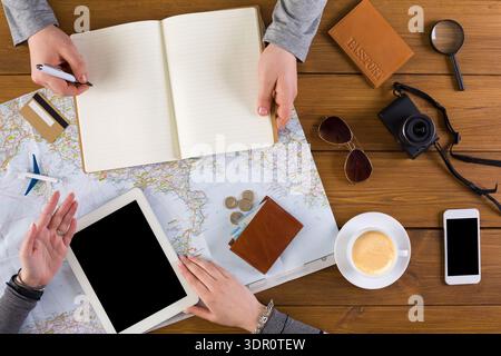 Planning a Trip With Maps, Devices, and Notes on a Wooden Table With Coffee Stock Photo