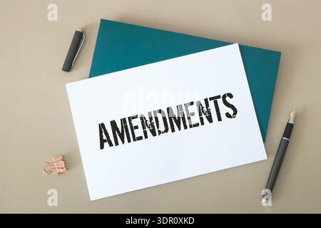 Hand holding a paper card with the word AMENDMENT. Stock Photo