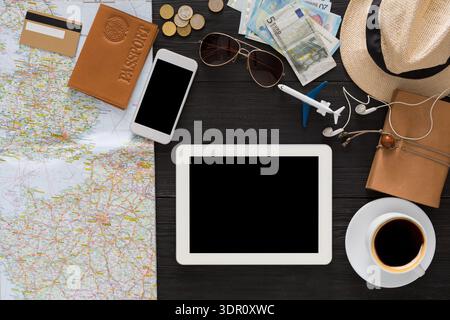 Planning a Trip With a Map, Travel Items, and Personal Belongings on a Table Stock Photo