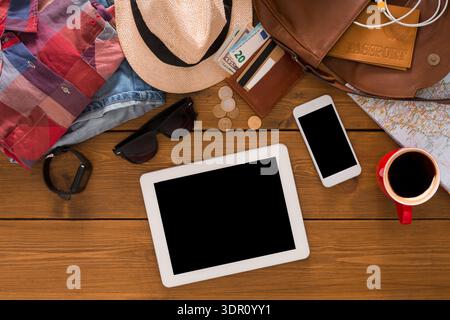 Travel Essentials Laid out on a Wooden Table for a Trip Planning Session Stock Photo