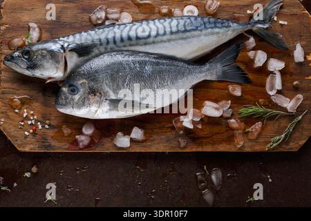 Fresh Fish Ready for Cooking on a Wooden Cutting Board With Ice and Herbs Stock Photo