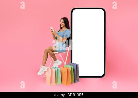 Happy lady with shopping bags sitting near mobile phone screen Stock Photo