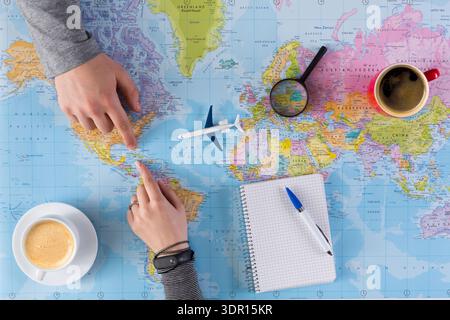 Planning a Trip While Looking at a World Map and Sipping Coffee in the Afternoon Stock Photo