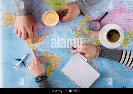 Planning a Trip While Looking at a Map With Coffee and Notepad on the Table Stock Photo