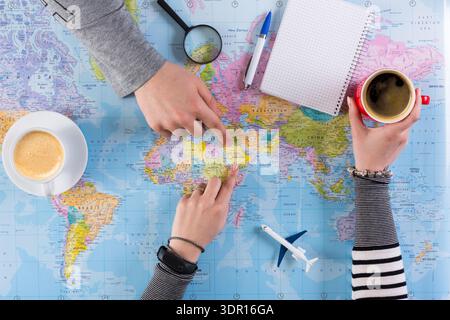 Planning a Trip on a World Map With Coffee and Notes During the Daytime Stock Photo