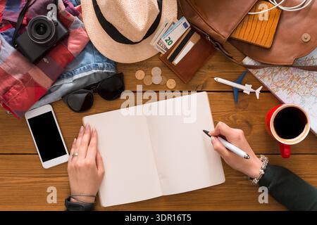 Planning a Travel Adventure With Notes, Maps, and Essentials on a Wooden Table Stock Photo