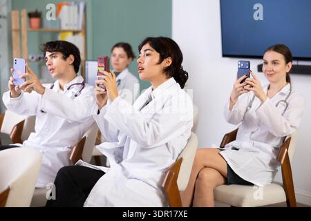 Malaysian woman using mobile phone and scanning barcode of lecture Stock Photo