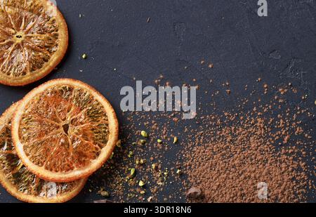 Dried Orange Slices and Cocoa Powder Placed on Dark Surface in Kitchen Setting Stock Photo