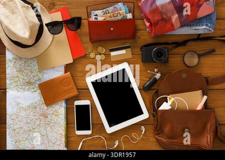 Planning for a Travel Trip With Various Items Laid out on a Wooden Table Stock Photo