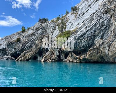 Scenic landscape with turquoise blue lake water surrounding dramatic natural rock formations on General Carrera Lake near the Marble Cathedral. Stock Photo