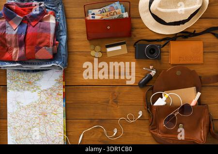 Planning a Travel Trip With Essentials Laid out on a Wooden Table for an Upcoming Adventure Stock Photo
