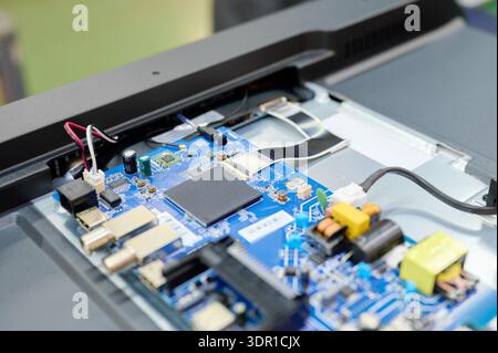 Assembly line at TV manufacturing facility showing intricate circuit board components in progress Stock Photo