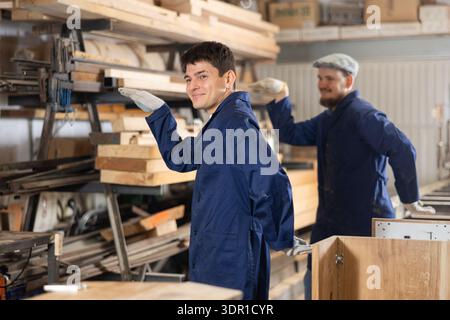 Young men doing exercises in wood workshop Stock Photo