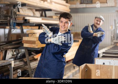 Young men doing exercises in wood workshop Stock Photo