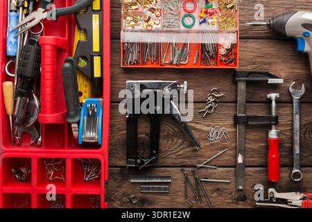 Various Tools and Fasteners Are Organized on a Wooden Work Surface for a Repair Project Stock Photo