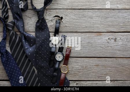 Collection of Ties and Watches on Wooden Surface in a Casual Setting Stock Photo