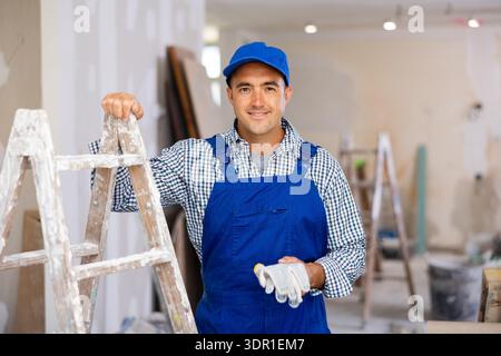 Waist-up portrait of positive man builder in coverall Stock Photo