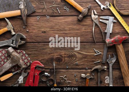 Various Types of Tools and Hardware Are Arranged on a Wooden Surface in a Workshop Setting Stock Photo