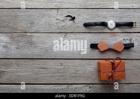 Watch, Bow Tie, and Gift on Wooden Surface for a Special Occasion Celebration Stock Photo