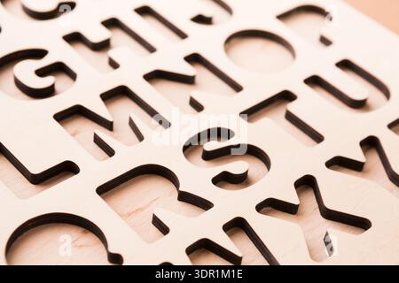 Wood Cutout of Letters Arranged in a Grid Pattern on a Flat Surface for Crafting Stock Photo