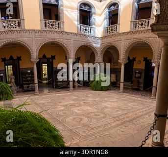 Panoramic view of the tiled courtyard with Roman mosaic pavement and carved arches at the Palace of the Countess of Lebrija in Seville, Andalusia, Spa Stock Photo