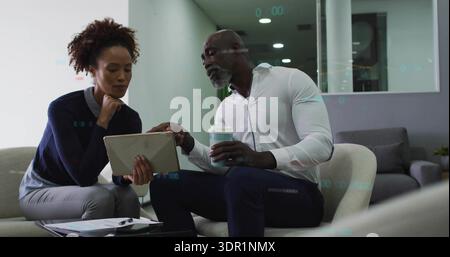 Reviewing tablet, two colleagues in office wear discussing file in work lounge with coffee, papers Stock Photo