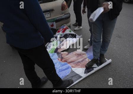 Damascus, Syria. December 8th 2025. Syrians stamp on a poster of the former Syrian president Bashar al Assad during celebrations after one year of the Stock Photo