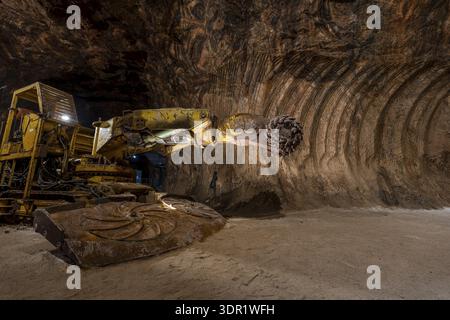 Tunnel boring machine operating inside an underground rocksalt mine in Loule, Algarve, showcasing heavy mining equipment, rugged mineral walls, and d Stock Photo