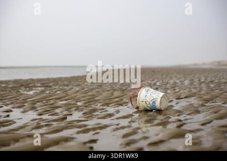 A discarded plastic cup is lying on a sandy beach, Blankenberge, Flanders, Belgium Stock Photo