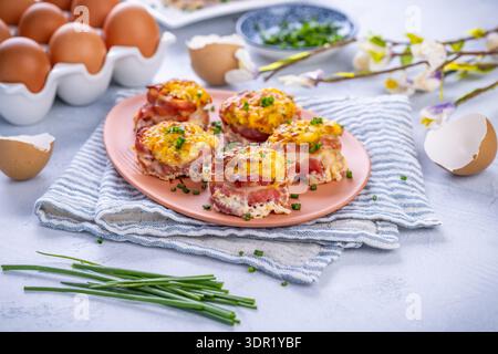 Bacon and eggs muffins for Easter brunch with chives Stock Photo