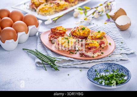 Bacon and eggs muffins for Easter brunch with chives Stock Photo