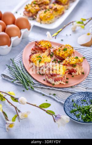Bacon and eggs muffins for Easter brunch with chives Stock Photo
